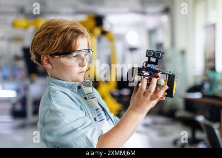 Porträt eines Schülers, der ein Roboterauto im Robotikclub der Schule baut. Kinder, die Robotik in der Grundschule lernen. Wissenschaft für Kinder. Stockfoto