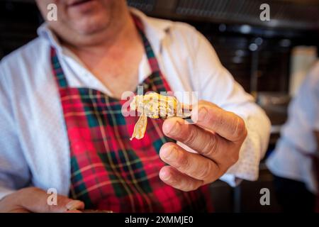 Gefüllte Muscheln Mit Straßengeschmack. Hand Hält Muschel. Haufen schwarzer Muscheln. Stockfoto