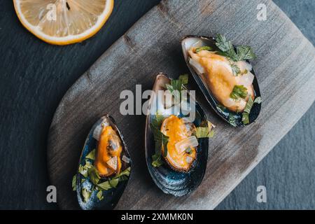 Muscheln in Weinsauce mit Petersilie auf grauem Stein und grauem Hintergrund gekocht. Hochwertige Fotos Stockfoto