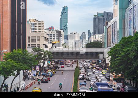 Bangkok, Thailand - 28. Juli 2024 - Blick auf die belebte Straße in der Nähe von Siam Ceter mit dem Hochhaus des Maha Nakorn im Hintergrund Stockfoto