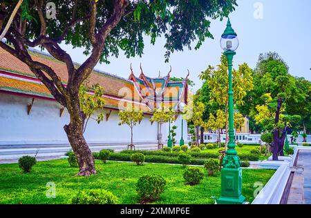 Der Innenhof des Wat Suthat Tempels und kleiner Garten mit Bäumen, Bangkok, Thailand Stockfoto