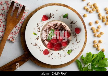 Köstliches Himbeermousse mit roten Beeren aus der Sicht über dem Kopf. Tisch mit Weihnachtsdekoration. Stockfoto