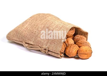 Walnüsse in einem Jutebeutel vor weißem Hintergrund Stockfoto