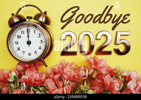 Auf Wiedersehen 2025 Text mit Alarm und Blumendekoration auf gelbem Hintergrund Stockfoto