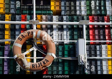 Cres, Kroatien - 11. April 2023: Ein alter Lifebuoy hängt an einem sonnigen Tag vor Kisten Stockfoto