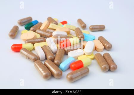 Verschiedene Arten von Arzneimitteltabletten, Kapseln und Kapseln in Nahsicht auf weißem Hintergrund verstreut. Stockfoto