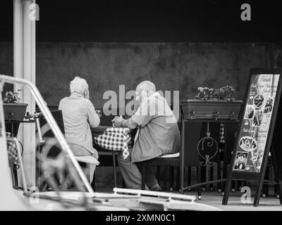 Cres, Kroatien - 25. Oktober 2022: Ein altes Paar sitzt bei Tageslicht in einem Restaurant Stockfoto