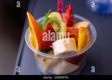 Eine Schüssel Obst mit einem Plastiklöffel darin Stockfoto
