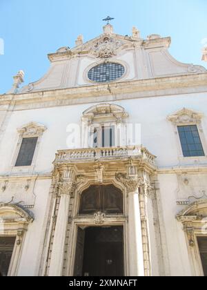 Barocke Kirchenfassade mit Säulen, verzierten Details und einem Kreuz Stockfoto