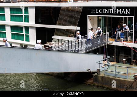 Die Köche des Kreuzfahrtschiffs The Gentleman transportieren Waren über den Bootssteg an Bord, Köln, Deutschland. Koeche des Kreuzfahrtschiffes trägt Waren Stockfoto