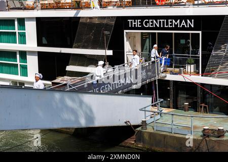 Die Köche des Kreuzfahrtschiffs The Gentleman transportieren Waren über den Bootssteg an Bord, Köln, Deutschland. Koeche des Kreuzfahrtschiffes trägt Waren Stockfoto