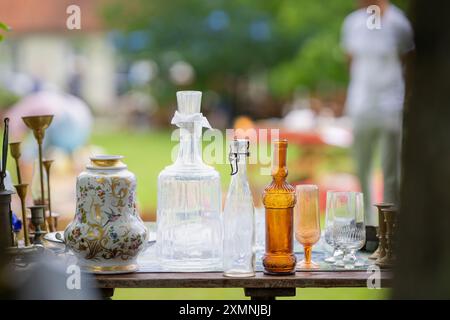 Flohmarkt Vintage-Theke mit Vintage-Glasflaschen, Bechern, Karaffen und anderen alten Dingen. Verschiedene Antiquitäten auf dem Flohmarkt. Stockfoto