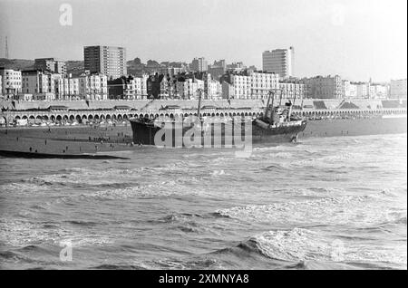 Die Athina B, ein seltenes Schiffswrack am Brighton Beach, wurde kurzzeitig zu einer riesigen Touristenattraktion, nachdem sie einen Motorausfall erlitt, als sie versuchte, während eines heftigen Sturms in den Shoreham Harbour zu gelangen. Sie driftete nach Osten, verpasste den Brighton Palace Pier (hier im Hintergrund zu sehen) mit einem Whisker und ging mit solcher Gewalt an den Strand. Es dauerte fast einen Monat, bis Bergungsarbeiter sie entladen und abschleppten. Sie verließ am 21. Februar 1980, bejubelt von einer großen Menschenmenge, und wurde nun verschrottet. Dieses Foto wurde am Morgen aufgenommen, nachdem sie an Land gelaufen war.21 Januar 1980 Foto von Roger Bamber Stockfoto