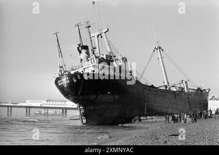 Die Athina B, ein seltenes Schiffswrack am Brighton Beach, wurde kurzzeitig zu einer riesigen Touristenattraktion, nachdem sie einen Motorausfall erlitt, als sie versuchte, während eines heftigen Sturms in den Shoreham Harbour zu gelangen. Sie driftete nach Osten, verpasste den Brighton Palace Pier (hier im Hintergrund zu sehen) mit einem Whisker und ging mit solcher Gewalt an den Strand. Es dauerte fast einen Monat, bis Bergungsarbeiter sie entladen und abschleppten. Sie verließ am 21. Februar 1980, bejubelt von einer großen Menschenmenge, und wurde nun verschrottet. Dieses Foto wurde am Morgen aufgenommen, nachdem sie an Land gelaufen ist. Foto von Roger Bamber Stockfoto