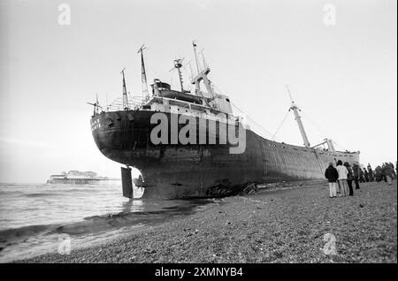 Die Athina B, ein seltenes Schiffswrack am Brighton Beach, wurde kurzzeitig zu einer riesigen Touristenattraktion, nachdem sie einen Motorausfall erlitt, als sie versuchte, während eines heftigen Sturms in den Shoreham Harbour zu gelangen. Sie driftete nach Osten, verpasste den Brighton Palace Pier (hier im Hintergrund zu sehen) mit einem Whisker und ging mit solcher Gewalt an den Strand. Es dauerte fast einen Monat, bis Bergungsarbeiter sie entladen und abschleppten. Sie verließ am 21. Februar 1980, bejubelt von einer großen Menschenmenge, und wurde nun verschrottet. Dieses Foto wurde am Morgen aufgenommen, nachdem sie an Land gelaufen war.21 Januar 1980 Foto von Roger Bamber Stockfoto