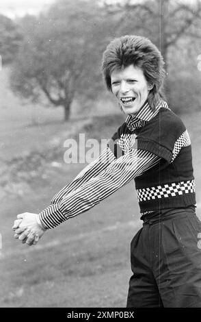 David Bowie 18. Oder 19. Mai 1973 aufgenommen am Ende der Schottland-Tour .... Sie reisten Aberdeen nach Edinburgh in vier Tagen kurz vor Lewisham am 24. Mai. Roger Bamber war mit ihnen im Tourbus und hielt den Bus an, um die Fotos zu machen, sodass er draußen einige „andere Sachen“ bei natürlichem Licht machen ließ. Cumbernauld, in der Nähe von Glasgow, und sie zogen einfach in einen Lay-by nahe einem schönen Dorfgrün, Bowie sprang raus und posierte auf, sie machten nur ein paar Fotos, hatten eine Tasse Tee und drückten sich auf. Prämienerhebung: ES FALLEN MINDESTGEBÜHREN an, bitte wenden Sie sich an requests@topfoto.co.uk Stockfoto