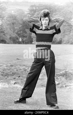 David Bowie 18. Oder 19. Mai 1973 aufgenommen am Ende der Schottland-Tour .... Sie reisten Aberdeen nach Edinburgh in vier Tagen kurz vor Lewisham am 24. Mai. Roger Bamber war mit ihnen im Tourbus und hielt den Bus an, um die Fotos zu machen, sodass er draußen einige „andere Sachen“ bei natürlichem Licht machen ließ. Cumbernauld, in der Nähe von Glasgow, und sie zogen einfach in einen Lay-by nahe einem schönen Dorfgrün, Bowie sprang raus und posierte auf, sie machten nur ein paar Fotos, hatten eine Tasse Tee und drückten sich auf. Prämienerhebung: ES FALLEN MINDESTGEBÜHREN an, bitte wenden Sie sich an requests@topfoto.co.uk Stockfoto