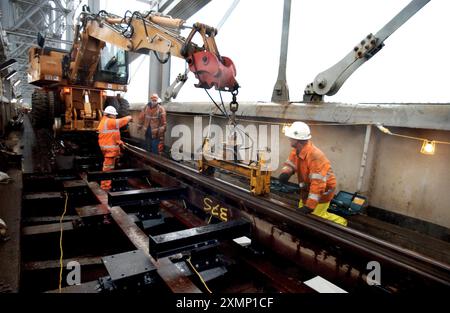 Bild von Roger Bamber: 22. Januar 2003: Eine Renovierung der Royal Albert Bridge über den Tamar in Höhe von 3 Millionen Pfund wird die ursprüngliche Hartholz-Bahnstation von Isambard Kingdom Brunel wiederherstellen, die ursprünglich von der Bauzeit 1859 bis in die 1920er Jahre genutzt wurde Ingenieure fanden heraus, dass moderne Schwellen und Ballastbetten eine größere Ermüdung des Metalls an der Struktur verursachen. Die Brücke verbindet Devon und Cornwall. Die Bilder zeigen einen Straßen-/Schienenkran, der neue Gleise auf dem Ekki-Hartholz auf der Brücke verlegt. Stockfoto