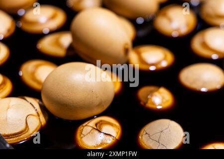 Nahaufnahme von Teeeiern, das sind Hühnereier, die in Tee und Kräutern gekocht werden, ein chinesisches Rezept für Wohlbefinden. Stockfoto