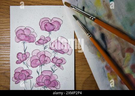 Ein einladender Arbeitsbereich für Künstler mit einem lebendigen Aquarellgemälde von Blumen in Bearbeitung. Illustrieren, Kreativität, Kunsttechniken, künstlerisch. Stockfoto