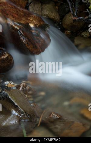 Abstraktes Detail des Wassers, das über Felsen in einem Gebirgsbach in der Nähe von Ballachulish, Glencoe, Schottland, Großbritannien fließt Stockfoto