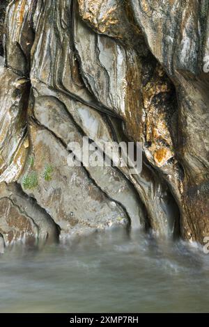 Abstraktes Detail des Wassers, das über Felsen in einem Gebirgsbach in der Nähe von Ballachulish, Glencoe, Schottland, Großbritannien fließt Stockfoto