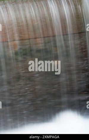 Abstraktes Detail des Wassers, das über Felsen in einem Gebirgsbach in der Nähe von Ballachulish, Glencoe, Schottland, Großbritannien fließt Stockfoto