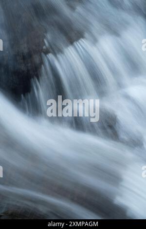 Abstraktes Detail des Wassers, das über Felsen in einem Gebirgsbach in der Nähe von Ballachulish, Glencoe, Schottland, Großbritannien fließt Stockfoto