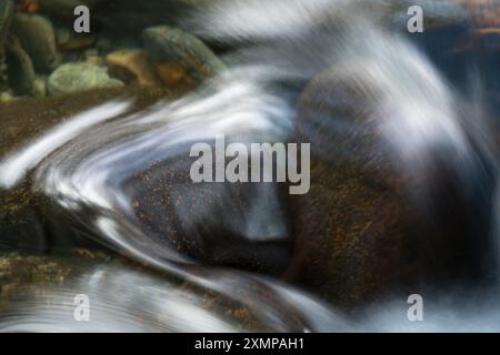 Abstraktes Detail des Wassers, das über Felsen in einem Gebirgsbach in der Nähe von Ballachulish, Glencoe, Schottland, Großbritannien fließt Stockfoto