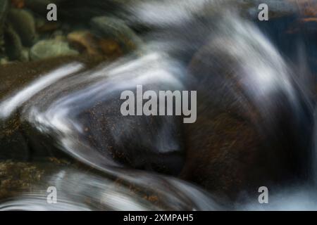Abstraktes Detail des Wassers, das über Felsen in einem Gebirgsbach in der Nähe von Ballachulish, Glencoe, Schottland, Großbritannien fließt Stockfoto