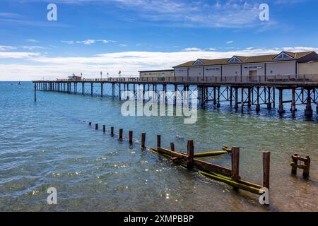 Groynes und der teilweise stillgelegte viktorianische Pier in Teignmouth in South Devon, England. Stockfoto