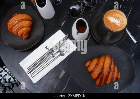 Ein einfaches Frühstück am Morgen, eine Tasse Café Latte und Croissant. Stockfoto