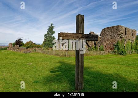 Das hölzerne Kreuz markiert die Altarposition der Balmerino Priory in der Nähe von Newport auf Tay, mit den verbleibenden Steinruinen im Hintergrund. Stockfoto