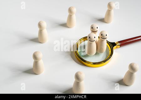 Vergrößerungsglas für Personalbeschaffung und Stellensuche mit Holzkonzept für Personalwesen und Auswahl der richtigen Mitarbeiter Stockfoto