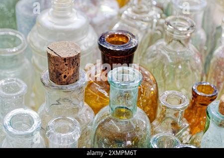 Große Gruppe von kleinen leeren Glasflaschen, alt und staubig. Abstrakter Vintage-Hintergrund. Stockfoto