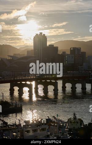 Dramatischer Sonnenuntergang über dem kleinen Fischerhafen in Busan, Südkorea Stockfoto