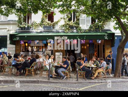 Paris, Frankreich, 07.28.2024 Personen genießen Mittagessen vor einem Restaurant in Abesses, Paris. Stockfoto