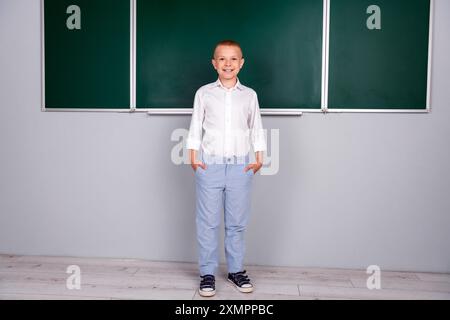 Foto eines charmanten, hübschen, fleißigen Schulkindes, der in der Nähe des grünen Bretts im Klassenzimmer antwortet Stockfoto