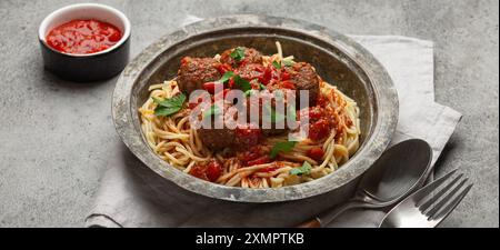 Spaghetti, serviert mit Fleischbällchen und Tomatensauce in rustikaler Schüssel, italienische Küche Stockfoto