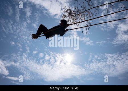 Der junge Mann schwingt auf Seil- und Bambusschaukel, die zeitweilig für das Diwali Festival of Lights im November in Panauti Town, Kathmandu, Nepal, eingerichtet wurden Stockfoto