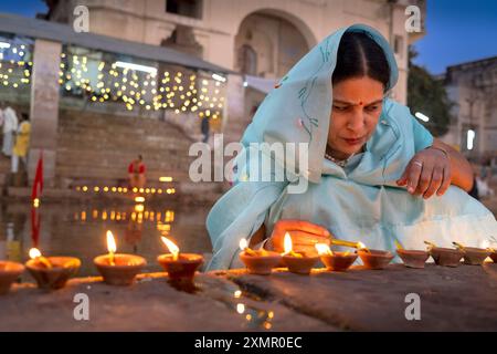 Eine Frau zündet Puja-Kerzen am Puskar-See während der Pushkar-Kamelmesse in Pushkar, Rajasthan, Indien, Asien an Stockfoto