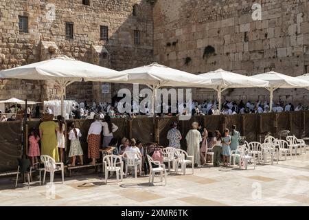 Weibliche jüdische Anbeter Klammern den Zaun, um auf die Männerseite der Westmauer zu schauen. Die Westmauer, auch bekannt als Klagemauer im Westen und Al-Buraq-Mauer im Islam, ist ein Pilgerziel für jüdische Gläubige. Es befindet sich in der Altstadt von Jerusalem und ist ein Teil der Stützmauer des Tempelbergs. Eine Metallwand teilte das Gebiet in zwei Teile auf: Männer auf der linken und Frauen auf der rechten Seite. Den ganzen Tag über besuchen jüdische Gläubige die Stätte, um zu beten, die heiligen Bücher der Thora zu lesen und Papiernotizen in den Rissen der Mauer zu hinterlassen. Das ganze Gebiet wird von israelischen Soldaten überwacht. Stockfoto