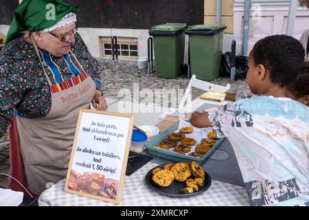 Frau, die Sklandrausis verkauft, eines der traditionellsten und einzigartigsten lettischen Gerichte, Stadtfest in Kuldiga, Lettland, 27. Juli 2024 Stockfoto