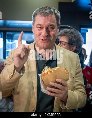 München, Deutschland. Juli 2024. Markus Söder (CSU), Ministerpräsident Bayerns, holt sich einen frischen Döner an der Theke in einem Dönerrestaurant ab. Söder hatte zuvor Kebabs an Instagram-Fans verlost. Quelle: Peter Kneffel/dpa/Alamy Live News Stockfoto