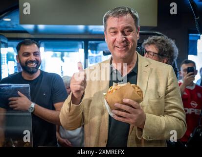 München, Deutschland. Juli 2024. Markus Söder (CSU), Ministerpräsident Bayerns, holt sich einen frischen Döner an der Theke in einem Dönerrestaurant ab. Söder hatte zuvor Kebabs an Instagram-Fans verlost. Quelle: Peter Kneffel/dpa/Alamy Live News Stockfoto