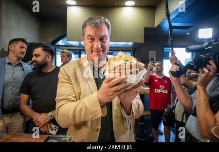 München, Deutschland. Juli 2024. Markus Söder (CSU), Ministerpräsident Bayerns, holt sich einen frischen Döner an der Theke in einem Dönerrestaurant ab. Söder hatte zuvor Kebabs an Instagram-Fans verlost. Quelle: Peter Kneffel/dpa/Alamy Live News Stockfoto