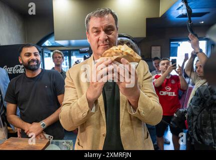 München, Deutschland. Juli 2024. Markus Söder (CSU), Ministerpräsident Bayerns, holt sich einen frischen Döner an der Theke in einem Dönerrestaurant ab. Söder hatte zuvor Kebabs an Instagram-Fans verlost. Quelle: Peter Kneffel/dpa/Alamy Live News Stockfoto