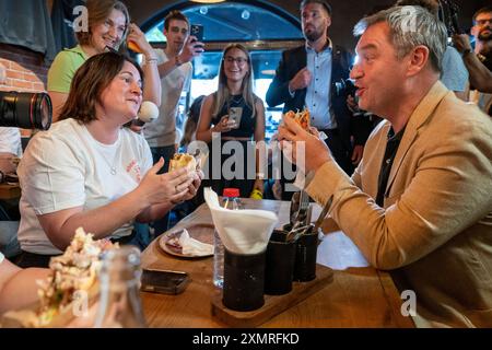 München, Deutschland. Juli 2024. Markus Söder (CSU), Ministerpräsident Bayerns, spricht mit geladenen Gästen in einem Dönerrestaurant. Söder hatte zuvor Kebabs an Instagram-Fans verlost. Quelle: Peter Kneffel/dpa/Alamy Live News Stockfoto