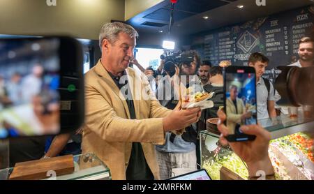 München, Deutschland. Juli 2024. Markus Söder (CSU), Ministerpräsident Bayerns, holt sich einen frischen Döner an der Theke in einem Dönerrestaurant ab. Söder hatte zuvor Kebabs an Instagram-Fans verlost. Quelle: Peter Kneffel/dpa/Alamy Live News Stockfoto