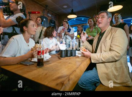 München, Deutschland. Juli 2024. Markus Söder (CSU), Ministerpräsident Bayerns, spricht mit geladenen Gästen in einem Dönerrestaurant. Söder hatte zuvor Kebabs an Instagram-Fans verlost. Quelle: Peter Kneffel/dpa/Alamy Live News Stockfoto